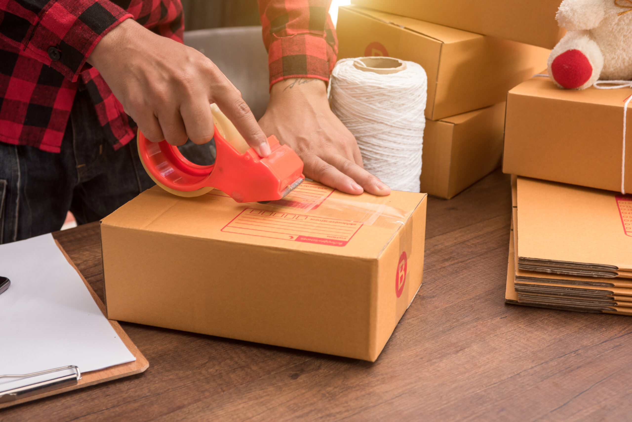 young-hand-woman-prepareing-package-be-sent-wooden-floor-scaled